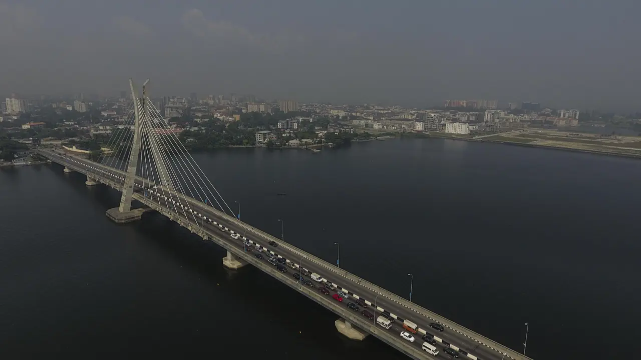 Aerial view of the Lekki-Ikoyi Link Bridge over the lagoon, with a line of cars and buses crossing.